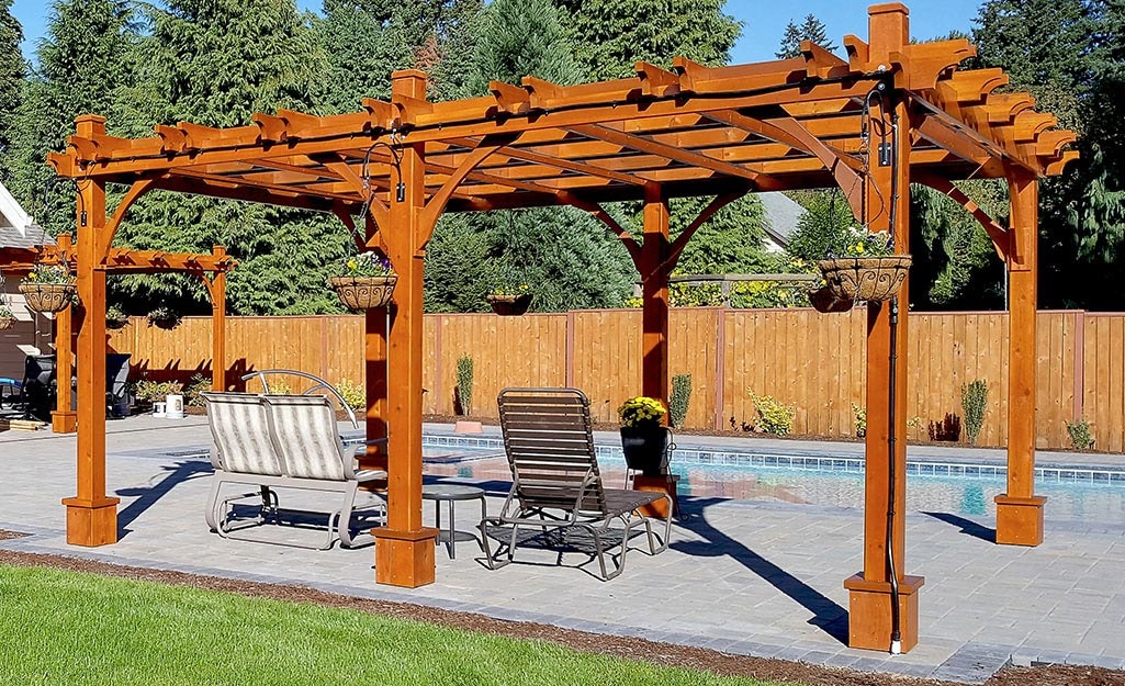 Wooden pergola over poolside patio seating