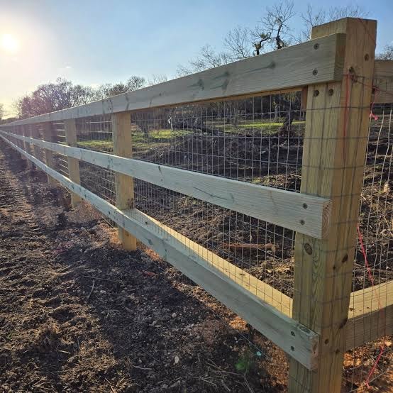 Wooden farm fence with wire mesh